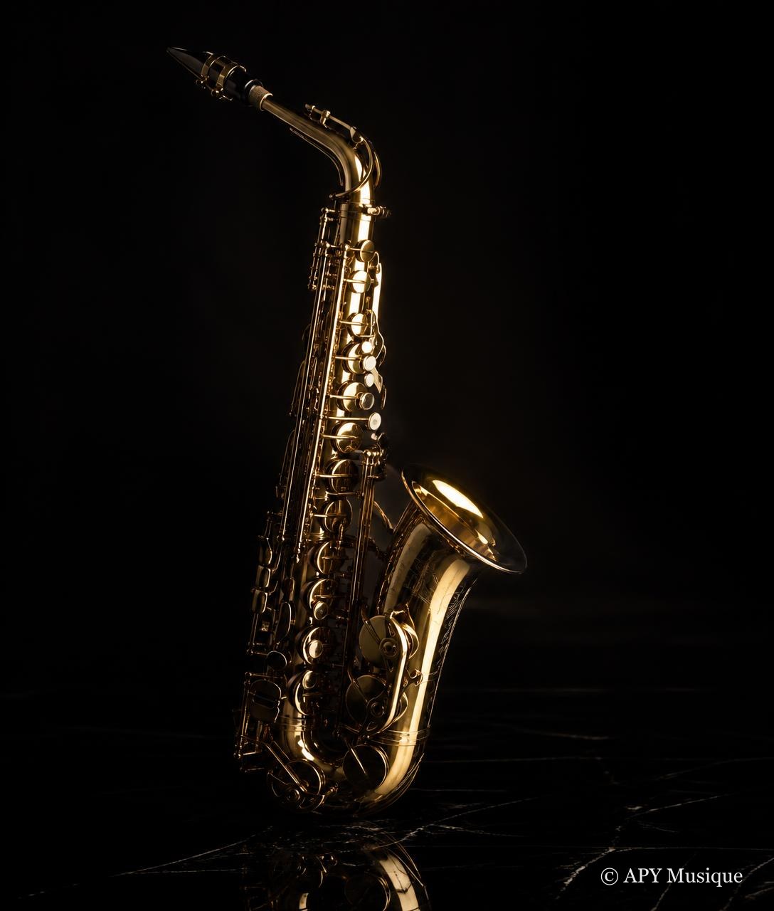 Saxophone en laiton poli sur une surface noire réfléchissante